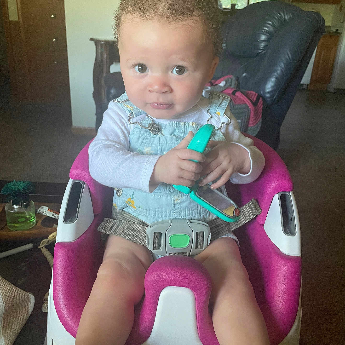 Jelisia joined the competition — help win amazing prizes! baby_seat, carpet, child, curly_hair, expression, furniture, green, holding, indoor, infant, kitchen, living_room, person, pink, seat_belt, toddler, toy, white, window, wooden_cabinet