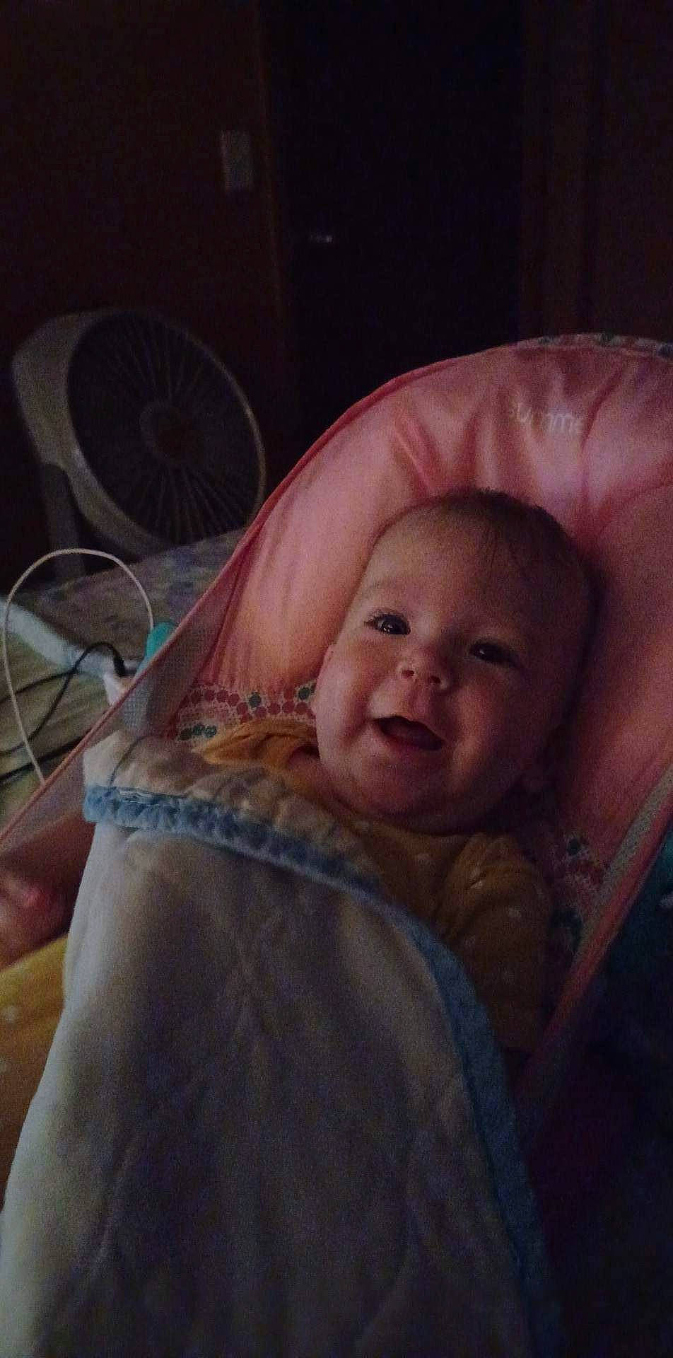 Hannah is registered to the contest to win money with this photo: baby, baby_toddler_clothing, cheek, child, comfort, eye, flash_photography, fun, happy, iris, linens, mouth, nose, person, room, sitting, skin, smile, thumb, toddler