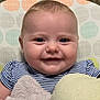baby, smile, face, blue_eyes, plush_toys, striped_clothing, infant, closeup, soft_texture, cheeks, cute, happy, child, patterned_background, polka_dots, head, skin, person, indoors, cuddly