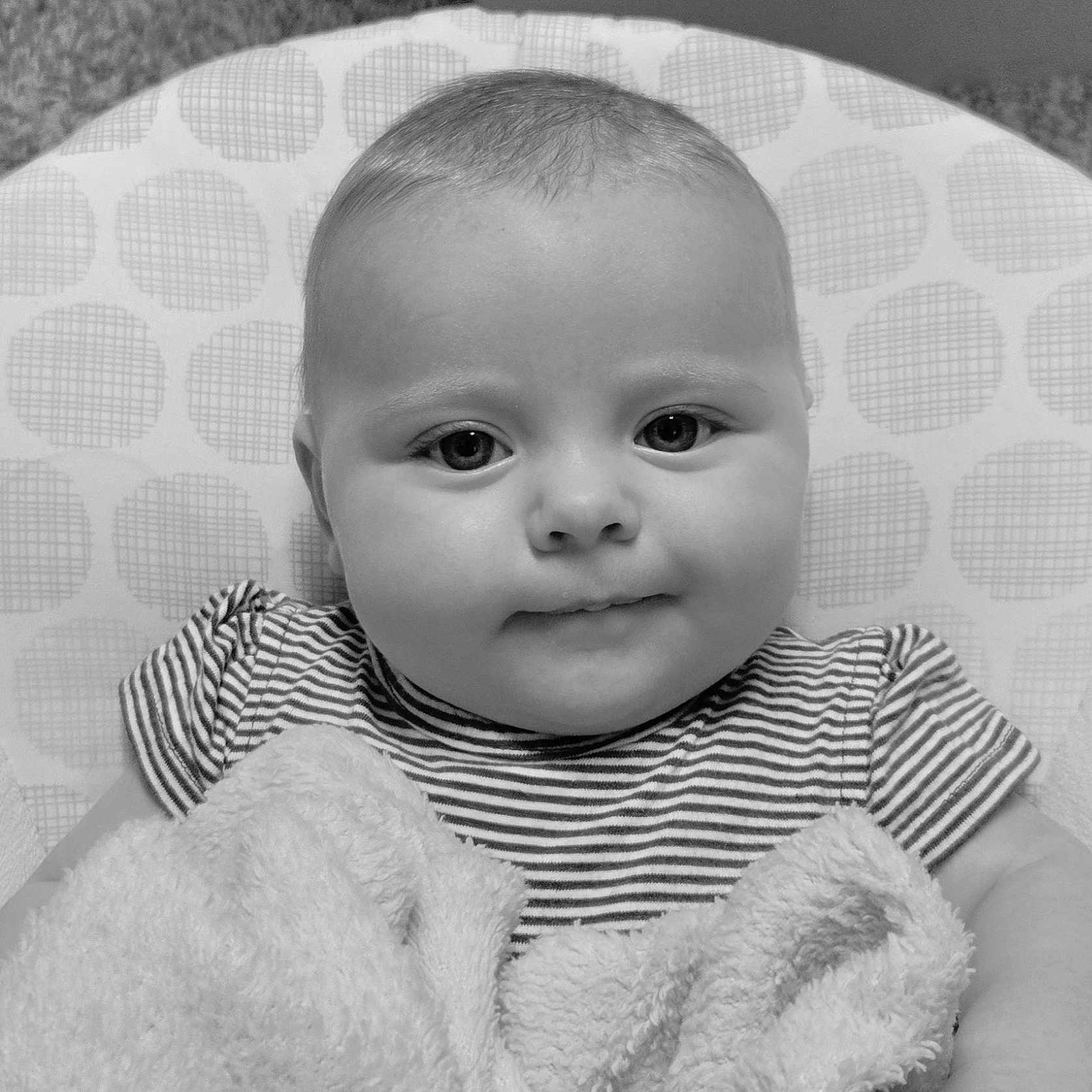 Evee joined the competition — help win amazing prizes! baby, black_and_white, blanket, child, chubby_cheeks, closeup, cushion, cute, face, head, indoor, infant, person, polka_dots, portrait, seated, smiling, soft_texture, striped_shirt, young