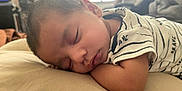 Adonais is registered to the contest to win money with this photo: baby, sleeping, pillow, infant, clothing, striped_shirt, face, peaceful, closeup, arm, resting, indoors, soft_light, young_child, portrait, skin, head, eyelashes, peace, calm