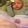baby, sleeping, headband, bow, blanket, pacifier, green, pink, cozy, infant, closeup, portrait, soft, cute, child, resting, indoors, textured_background, clothing, peaceful