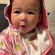 Evelyn joined the competition — help win amazing prizes! baby, child, hoodie, pink_clothing, animal_print, indoor, face, expression, cute, infant, portrait, clothing, young_child, apparel, person, casual, warm, cozy, sitting, hood