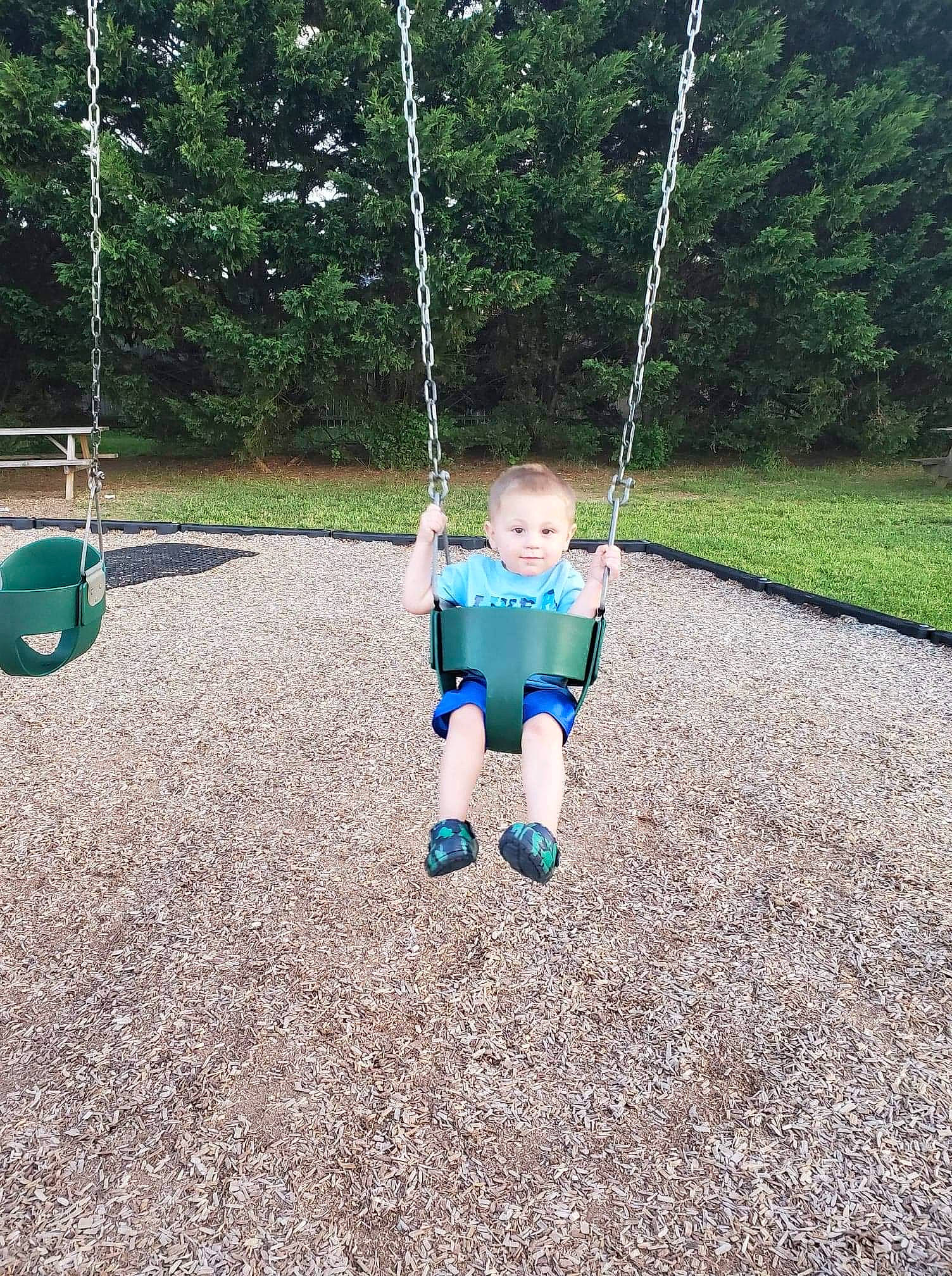 Daniel is registered to the contest to win money with this photo: baby, baby_toddler_clothing, ball, city, electric_blue, fun, grass, leisure, outdoor_play_equipment, people_in_nature, person, plant, play, playground, public_space, recreation, soil, swing, toddler, tree