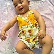 Aliyah is registered to the contest to win money with this photo: baby, child, smile, cute, romper, sunflower, yellow, blanket, elephant, stars, pastel, infant, happy, lying_down, soft_texture, cheerful, portrait, indoors, skin, head