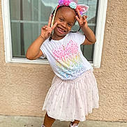 Zoey is registered to the contest to win money with this photo: accessories, child, clothing, face, female, footwear, girl, hair, head, jewelry, necklace, person, photography, portrait, racket, shoe, sitting, skirt, sleeve, sport