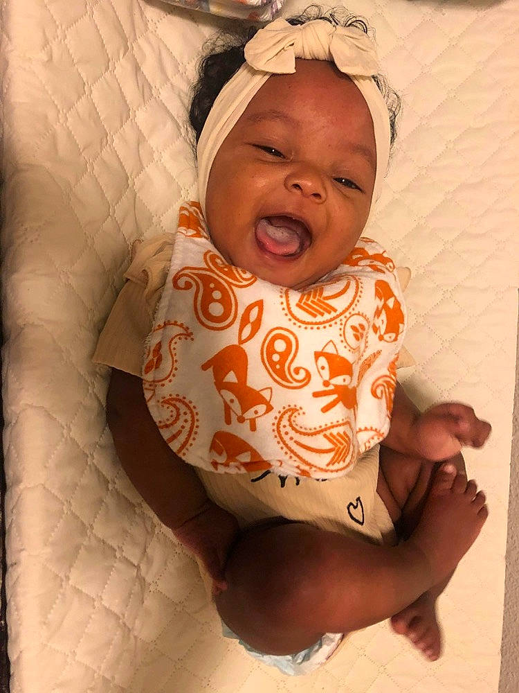 Amaia is registered to the contest to win money with this photo: baby, baby_toddler_clothing, cheek, chest, child, chin, comfort, finger, iris, lip, mouth, neck, nose, person, pink, skin, sleeve, smile, stomach, textile