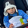 baby, blanket, blue_sweater, child, closeup, cold_weather, cute, face, hand, hat, infant, mickey_mouse, outdoor, person, playful, portrait, stroller, toddler, toy, warm_clothing