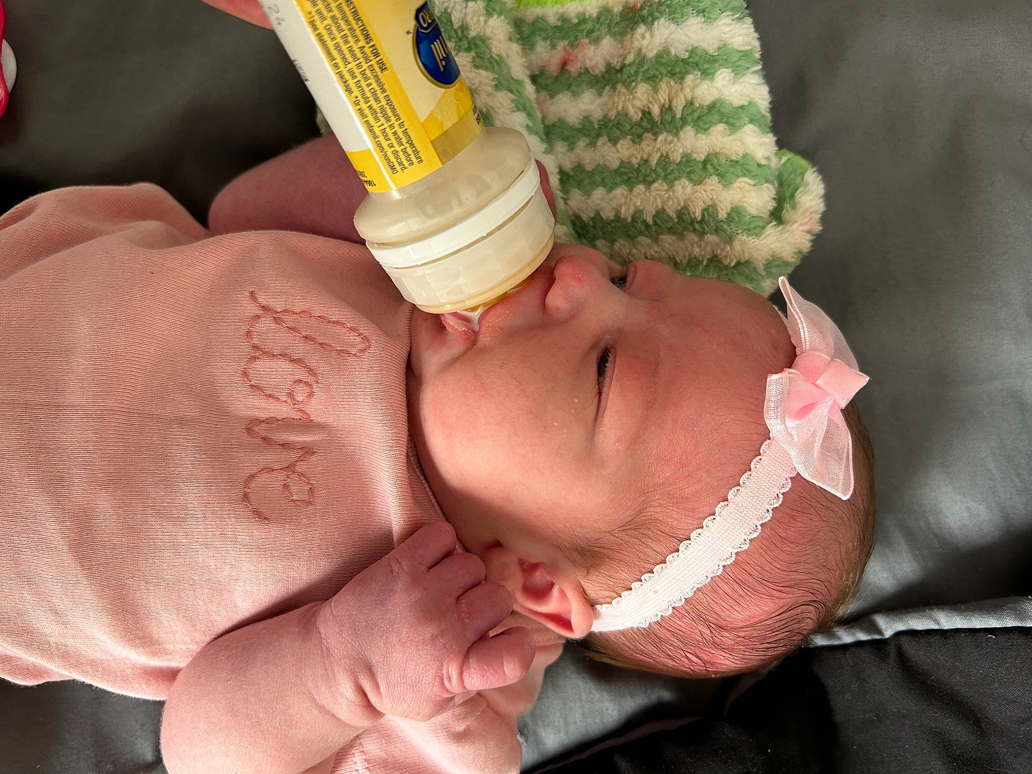 Kayleen is registered to the contest to win money with this photo: baby, bottle, cheek, drinkware, eye, eyelash, finger, hand, head, headgear, human_body, leg, nail, neck, nose, person, plastic_bottle, skin, thumb, toddler