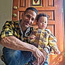 Noah is registered to the contest to win money with this photo: casual, child, family, father, front_door, home, indoors, jeans, parent, people, photography, plaid_shirt, portrait, smiling, stained_glass, standing, toddler, watch, wooden_door, yellow_clothing
