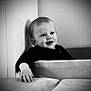baby, child, smile, black_and_white, couch, hand, indoors, portrait, young_child, happy, face, furniture, seated, infant, cute, monochrome, baby_clothing, home, young, people