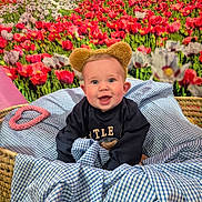 Emory joined the competition — help win amazing prizes! baby, child, basket, blue_checkered_fabric, bear_ears, smiling, happy, flower_background, red_flowers, white_flowers, indoor, cute, portrait, cozy, soft_toys, fabric, headwear, playful, infant, cheerful