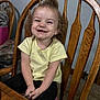 Marlee joined the competition — help win amazing prizes! toddler, child, smiling, curly_hair, yellow_shirt, black_pants, wooden_chair, indoor, carpet, happy, person, portrait, sitting, furniture, table, cute, young_child, casual_clothing, joyful, home