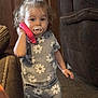 Marlee joined the competition — help win amazing prizes! toddler, child, indoor, curly_hair, pacifier, toy_phone, grey_outfit, daisy_pattern, carpet, furniture, couch, wooden_door, hand, standing, expression, cute, clothing, person, young_child, home