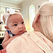Nova Leigh is registered to the contest to win money with this photo: baby, child, infant, portrait, face, eyes, headband, bow, blanket, pink, shoulder, holding, indoor, home, chandelier, stained_glass, window, bright, family, cute