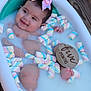 baby, infant, milk_bath, marshmallows, bow, wooden_sign, five_months, smiling, cute, tub, water, outdoor, deck, skin, hand, foot, colorful, pastel, relaxing, child
