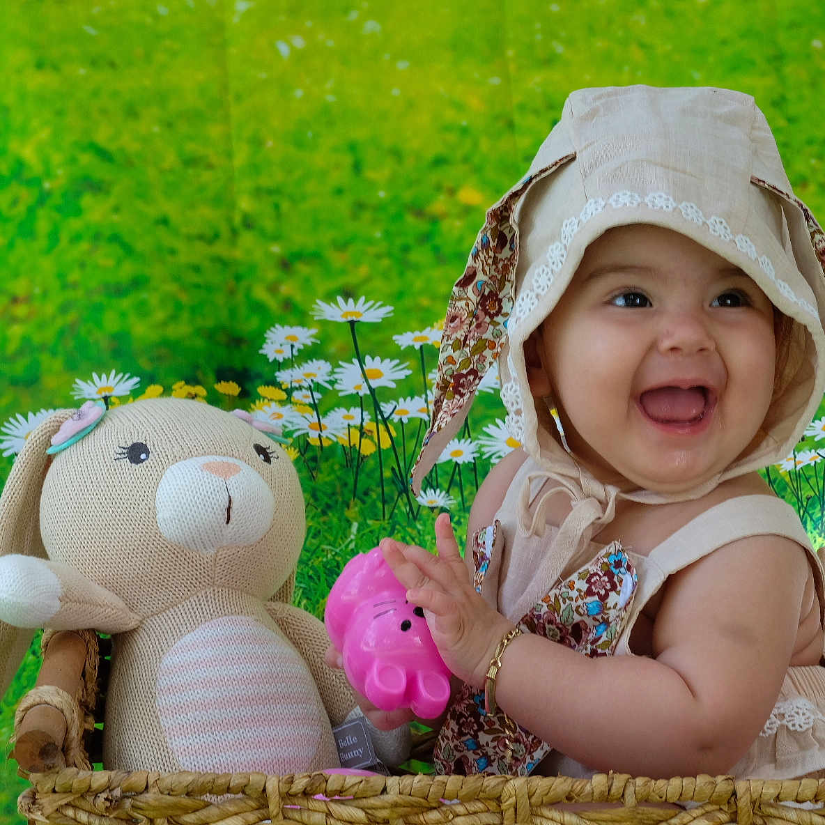 Hallie is registered to the contest to win money with this photo: baby, child, smiling, hat, bonnet, toy, stuffed_animal, bunny, basket, flower, greenery, daisy, cute, happy, infant, portrait, playful, indoors, colorful, young