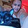 person, cat, tattoo, smiling, sleeping_cat, indoor, selfie, bedroom, string_lights, face, fur, whiskers, cozy, relaxing, close_up, arm, happy, resting, cute, pet