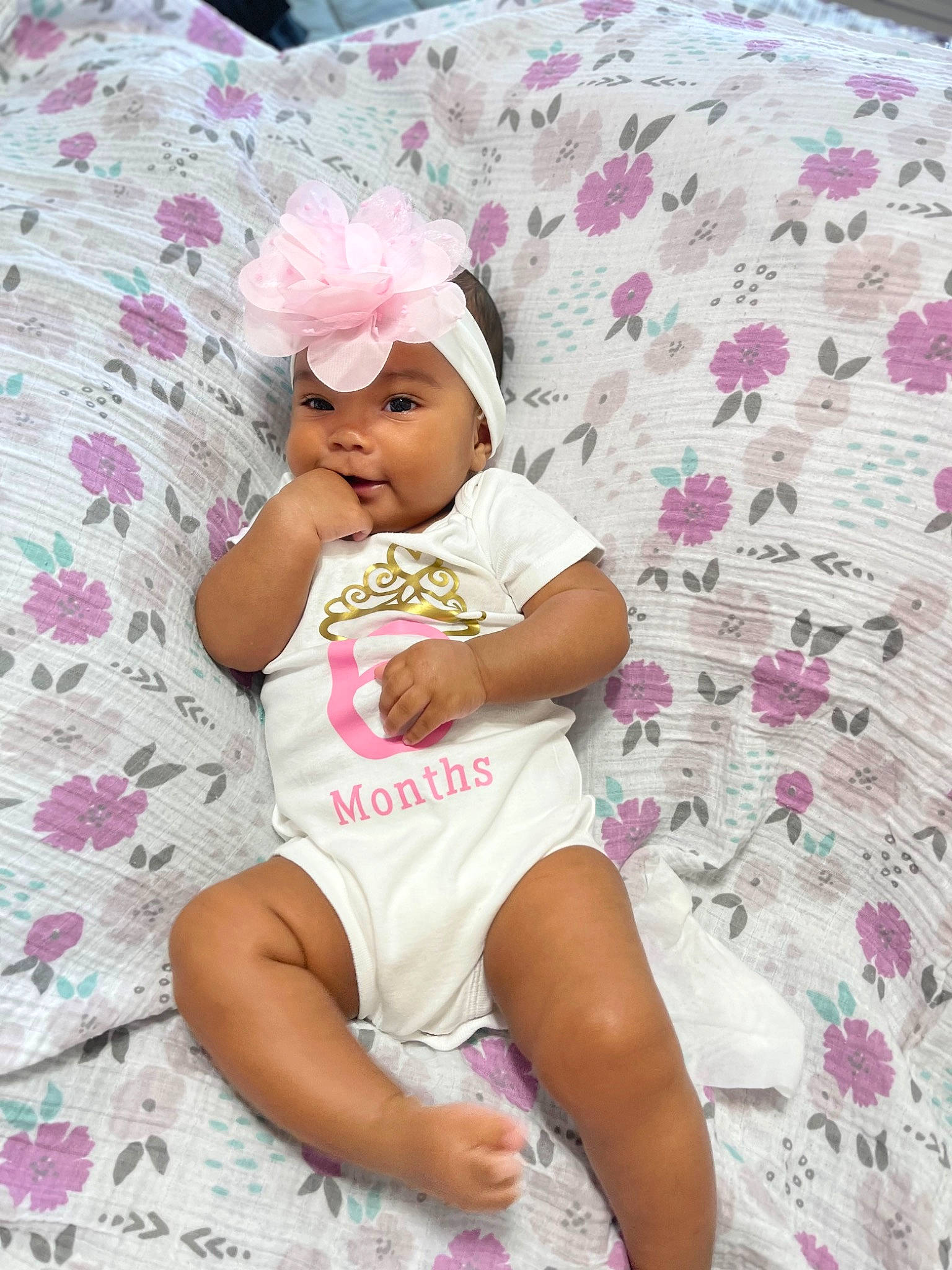 Nylah is registered to the contest to win money with this photo: arm, baby_toddler_clothing, child, comfort, fun, happy, hat, headgear, headwear, knee, leisure, linens, magenta, pattern, person, pink, purple, shorts, skin, t_shirt