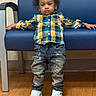 Adonis is registered to the contest to win money with this photo: child, toddler, plaid_shirt, distressed_jeans, white_sneakers, blue_chair, wooden_floor, indoor, serious_expression, curly_hair, casual_clothing, leaning, person, footwear, fashion, young_child, portrait, standing, relaxed_pose, cute