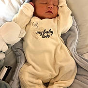 Evan participe au concours pour gagner de l'argent avec cette photo : baby, sleeping, onesie, infant, bed, soft, cozy, cute, child, newborn, padded_bed, resting, peaceful, baby_clothing, fabric, plush, face, head, hands, blanket