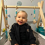 Nohé participe au concours pour gagner de l'argent avec cette photo : baby, child, smile, black_clothing, tracksuit, adidas, wooden_toy, beads, animal_toy, baby_gym, polka_dot, cushion, indoor, wall_decor, pastel_colors, happy, sitting, infant, cute, portrait