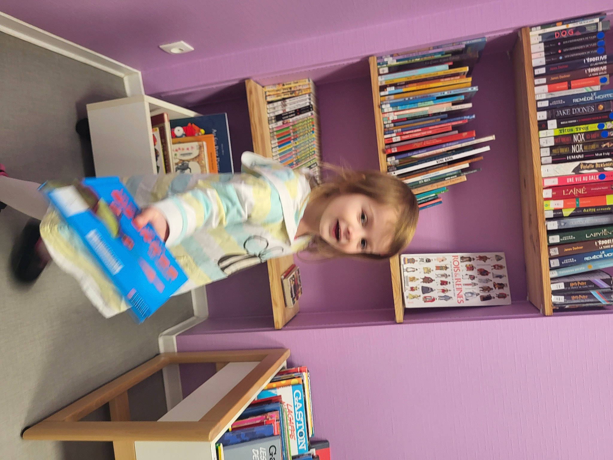 Lou participe au concours pour gagner de l'argent avec cette photo : book, bookcase, building, chair, child, fun, furniture, interior_design, learning, library, person, play, publication, retail, room, shelf, shelving, smile, snapshot, table