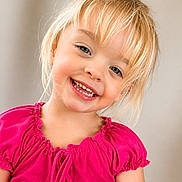 Ruby is registered to the contest to win money with this photo: child, girl, smile, happy, blonde_hair, pink_shirt, portrait, face, cute, young_child, casual_clothing, indoor, light_background, eyelashes, cheeks, teeth, skin, person, front_view, joyful