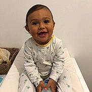 Liam participe au concours pour gagner de l'argent avec cette photo : baby, bed, blanket, bottle, child, cozy, cute, expression, face, footwear, furniture, happy, holding, indoor, pajamas, person, sitting, smiling, toddler, young