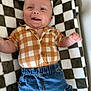 baby, smiling, checkered_shirt, denim_pants, blanket, plaid, happy, child, cute, infant, clothing, portrait, lying_down, indoor, face, hands, buttoned_shirt, blue_pants, texture, cozy