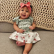 Gisele is registered to the contest to win money with this photo: baby, bodypart, bonnet, cap, clothing, couch, cushion, dress, face, finger, furniture, happy, hat, head, homedecor, person, photography, portrait, sitting, smile