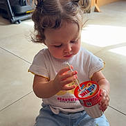 Valentina a rejoint le concours — aidez-le/la à gagner de superbes lots ! casual, child, concentrating, cup, curly_hair, cute, floor, home, indoor, natural_light, person, pigtails, playful, shorts, sitting, straw, tile_floor, toddler, white_tshirt, wooden_stairs