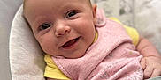 Julia joined the competition — help win amazing prizes! baby, smiling, infant, face, pink_bib, yellow_shirt, baby_seat, strapped_in, happy, cute, child, person, closeup, indoor, soft_fabric, disney_baby, portrait, skin, arm, young