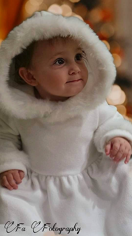 Lou participe au concours pour gagner de l'argent avec cette photo : arm, baby, baby_toddler_clothing, cheek, dress, eye, face, finger, fur_clothing, gesture, happy, head, headwear, lip, outerwear, person, pink, skin, sleeve, smile