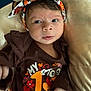 baby, brown_shirt, child, clothing, colorful, comfortable, cushion, cute, expression, face, hands, headband, holiday, indoor, infant, lying_down, portrait, soft_light, thanksgiving, young_child