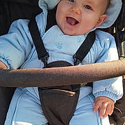 Tiago a rejoint le concours — aidez-le/la à gagner de superbes lots ! baby, child, smiling, hood, snowsuit, stroller, blue_clothing, happy, outdoor, infant, cute, face, warm_clothing, seatbelt, person, toddler, joyful, cold_weather, sitting, hands