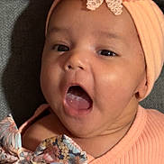 Josiris Isarel joined the competition — help win amazing prizes! baby, infant, headband, flower, open_mouth, peach_color, ribbed_clothing, bow, floral_pattern, close_up, portrait, skin, face, child, cute, expression, texture, fabric, soft_light, indoors