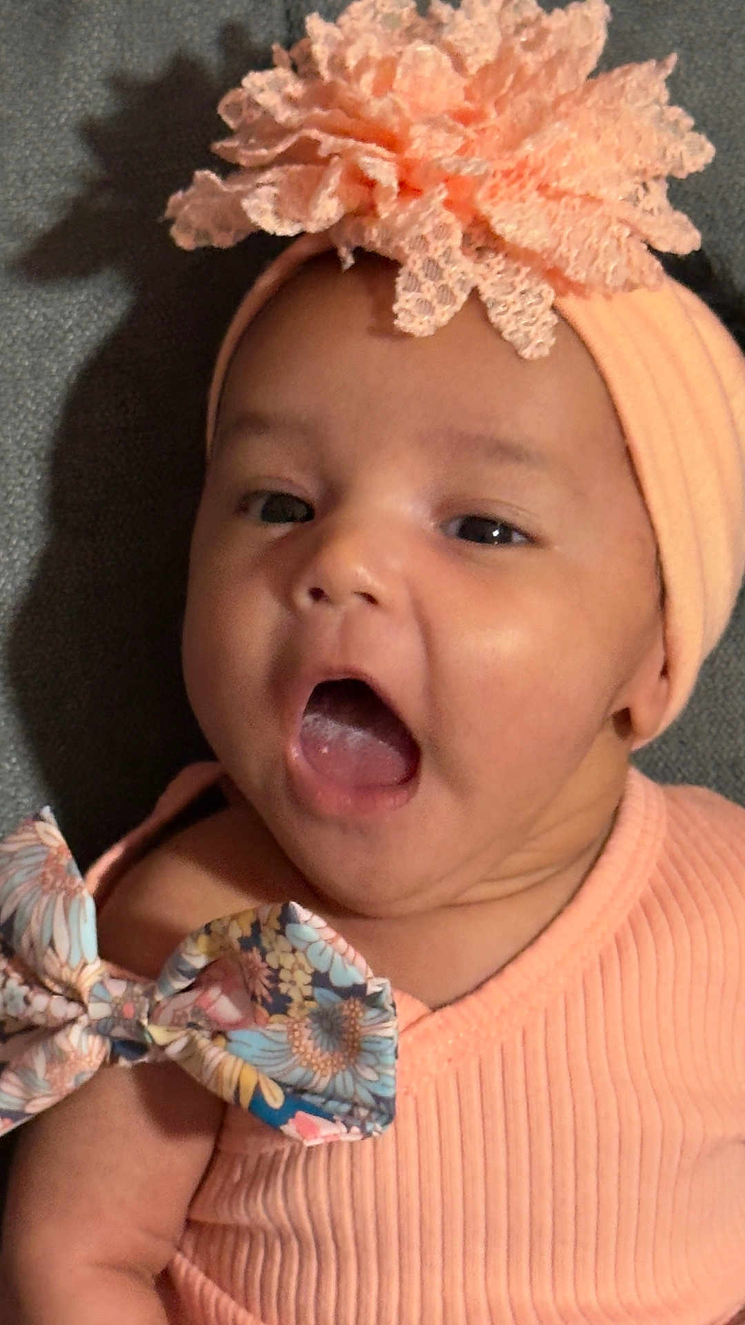 Josiris Isarel joined the competition — help win amazing prizes! baby, infant, headband, flower, open_mouth, peach_color, ribbed_clothing, bow, floral_pattern, close_up, portrait, skin, face, child, cute, expression, texture, fabric, soft_light, indoors