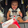 Torrin is registered to the contest to win money with this photo: baby, child, infant, car_seat, shopping, store, indoor, sitting, smiling, open_mouth, harness, seatbelt, black_car_seat, clothing, barefoot, product_packaging, bandages, foreground, portrait, happy