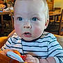 Caleb joined the competition — help win amazing prizes! baby, child, indoor, striped_shirt, toy, blue_eyes, curious, high_chair, wooden_table, people, restaurant, blurred_background, cute, chubby_cheeks, casual_clothing, hands, portrait, infant, bright_lighting, person
