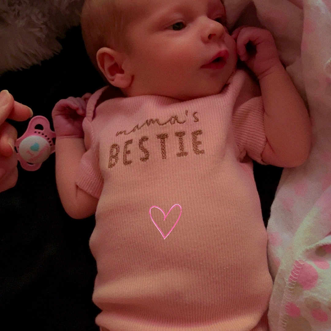 Wrenley is registered to the contest to win money with this photo: adorable, baby, blanket, child, comfort, cute, face, foot, hand, indoor, infant, lying_down, newborn, onesie, pacifier, peaceful, pink_clothing, resting, sleepwear, soft_texture