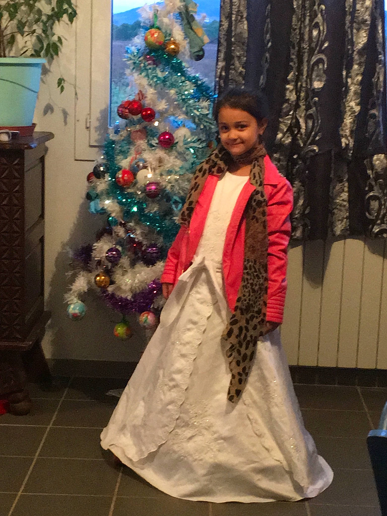 Lucas participe au concours pour gagner de l'argent avec cette photo : ceremony, christmas, christmas_decoration, christmas_tree, costume, dress, event, fashion, formal_wear, girl, gown, holiday, joy, outerwear, person, tradition, tree
