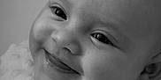 Charley is registered to the contest to win money with this photo: baby, smiling, face, black_and_white, portrait, infant, close_up, blanket, cute, happy, soft_texture, cheeks, eyes, tongue, head, expression, person, newborn, skin, innocence