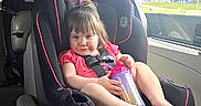 Katelynn is registered to the contest to win money with this photo: toddler, child, car_seat, vehicle_interior, sippy_cup, window, gas_station, greenery, pink_clothing, black_car_seat, seatbelt, cheeky_smile, hair_tie, footwear_free, car_door, daylight, seat, baby, portrait, sitting