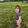 Katelynn joined the competition — help win amazing prizes! toddler, child, grass, field, outdoor, person, shorts, shirt, trees, sky, people, playful, smile, daylight, fun, nature, sports_field, casual, shoes, necklace