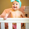 baby, crib, headband, bow, pink_diaper, nursery, child, infant, smiling, happy, indoor, furniture, cute, person, portrait, standing, colorful, decor, toddler, soft_lighting