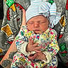 Victoria is registered to the contest to win money with this photo: newborn, baby, sleeping, hat, bow, floral_clothing, hand, tattoo, blanket, holiday_theme, beer_mug, beer_bottle, colorful, patterned, cozy, infant, cute, portrait, resting, indoor