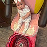 Sonia is registered to the contest to win money with this photo: baby, bow, headband, pink_chair, worn, foot_spa, red_basin, wood_floor, pajamas, socks, infant, indoor, curious, seated, child, person, slipper, flooring, furniture, home