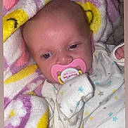 Bella joined the competition — help win amazing prizes! baby, infant, pacifier, blanket, onesie, star_pattern, sleepwear, cute, child, soft, cozy, pink, yellow, purple, white, face, hand, resting, indoors, portrait