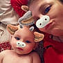 baby, adult, face_filter, animal_ears, animal_nose, lying_down, bed, pillow, red_clothing, skin, portrait, closeup, playful, cute, family, child, smile, relaxed, indoor, person